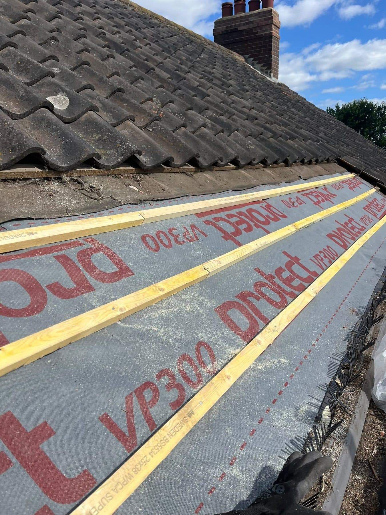 New membrane and battens on the lower part of a roof, below the old interlocking tiles