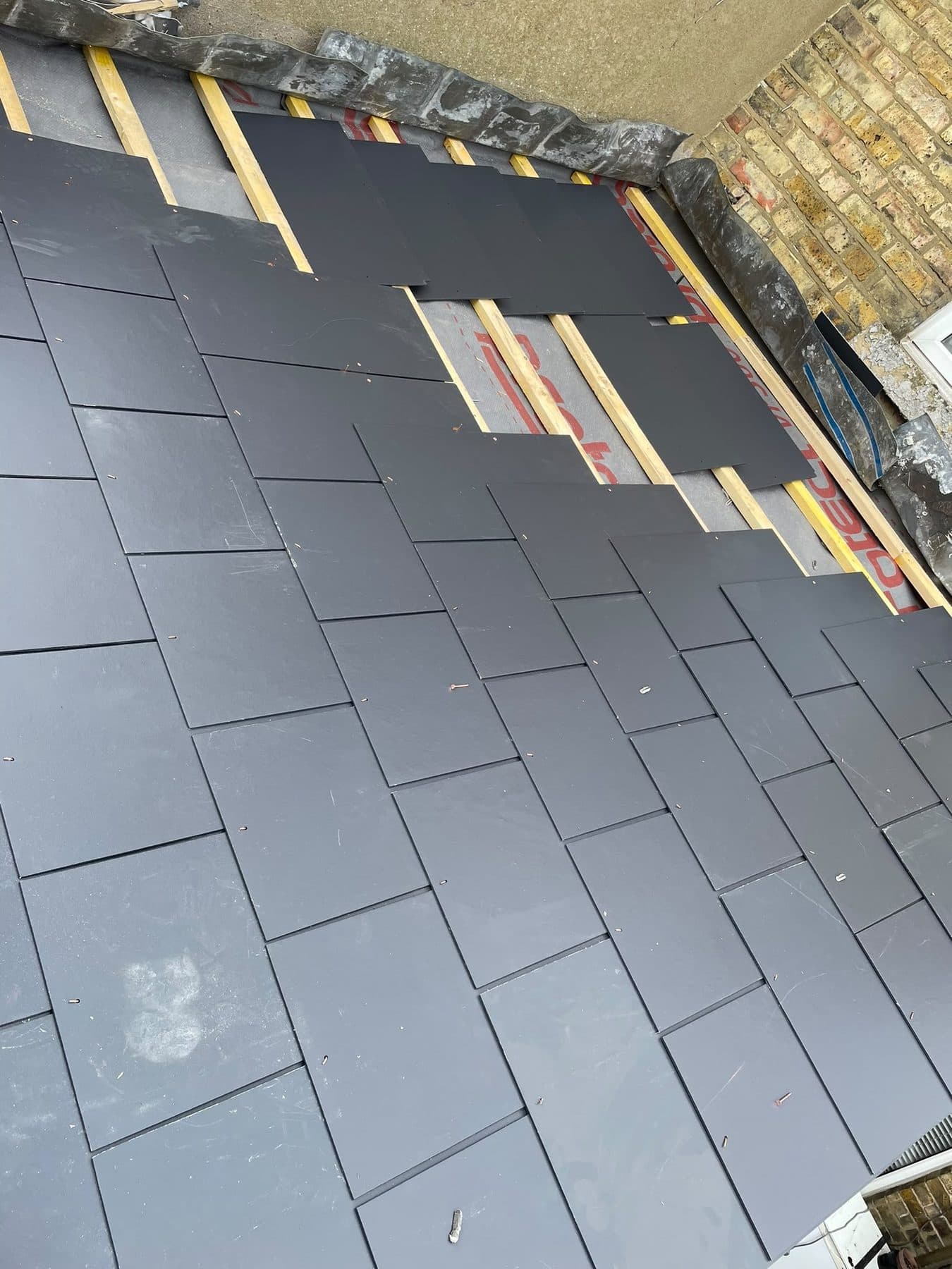 The same roof with new slates laid from the eaves up, the top courses still to go on
