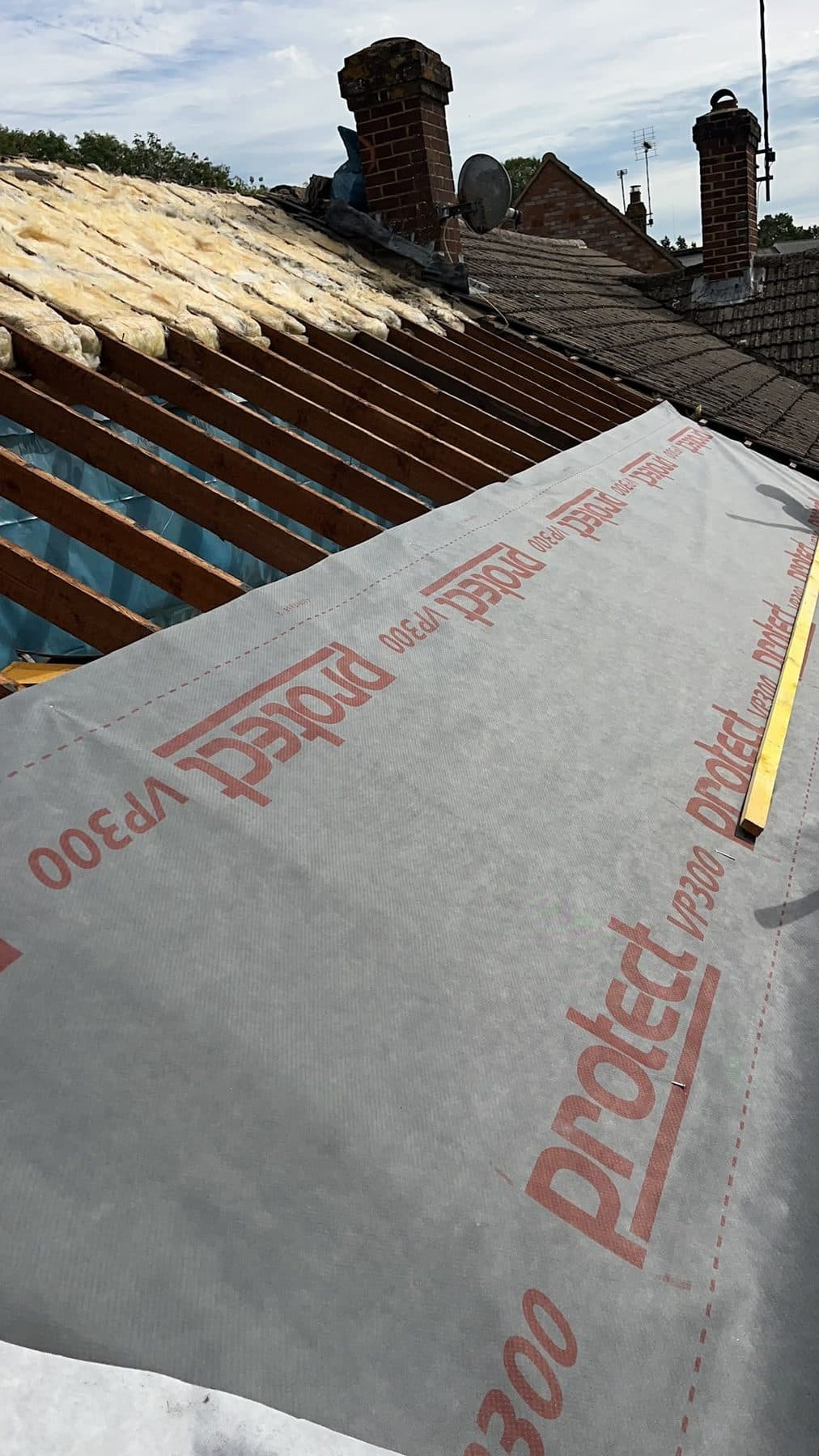 One part of a roof stripped to the rafters and the rest already covered in new membrane